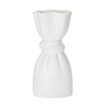 White ceramic vase with a delicate cinch midway that creates a graceful twist on a white background.