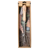 Hand-held gardening rake tool with wooden handle in a cardboard box