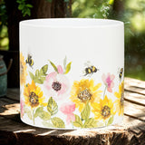 Decorative pot with floral and bee design on a wooden surface outdoors