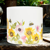 White container with floral and bee design on a wooden surface
