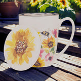 Mug and coaster with sunflower and bee design on a wooden surface