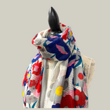 Colorful floral-patterned scarf on a mannequin against a light blue background