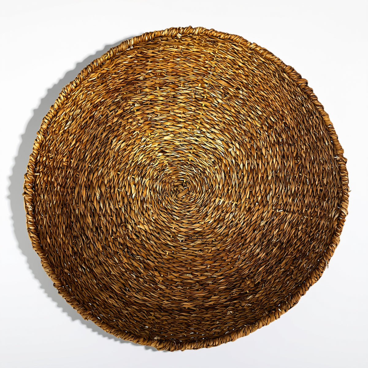 Round seagrass tray showing the intricate weave and structure from above 