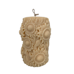 Decorative candle embossed with sunflowers with a light grey background