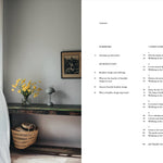 Room interior with a table, basket, and vase of flowers, alongside a book with text on a white background.