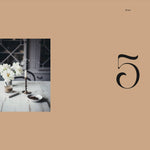 Table setting with flowers and cutlery on a beige background with number 5