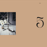 Table setting with flowers and cutlery on a beige background with number 5