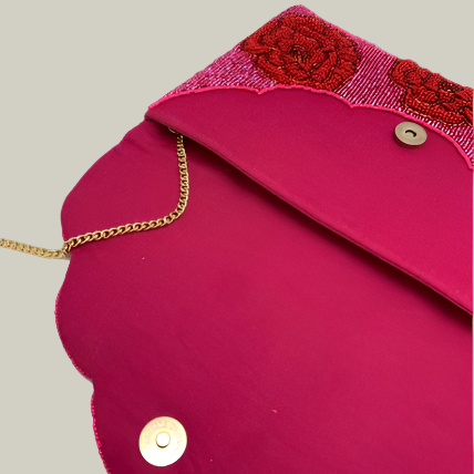 Pink clutch bag with red floral embroidery and gold chain strap