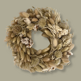 Exquisite 10-inch wreath made with lush white Statice, airy natural Oat Grass, feathery Lagers ovatus, and more creamy blooms. 