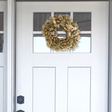 Exquisite 10-inch wreath made with lush white Statice, airy natural Oat Grass, feathery Lagers ovatus, and more creamy blooms on a white door with a window.