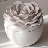Decorative candle in container with floral designed lid