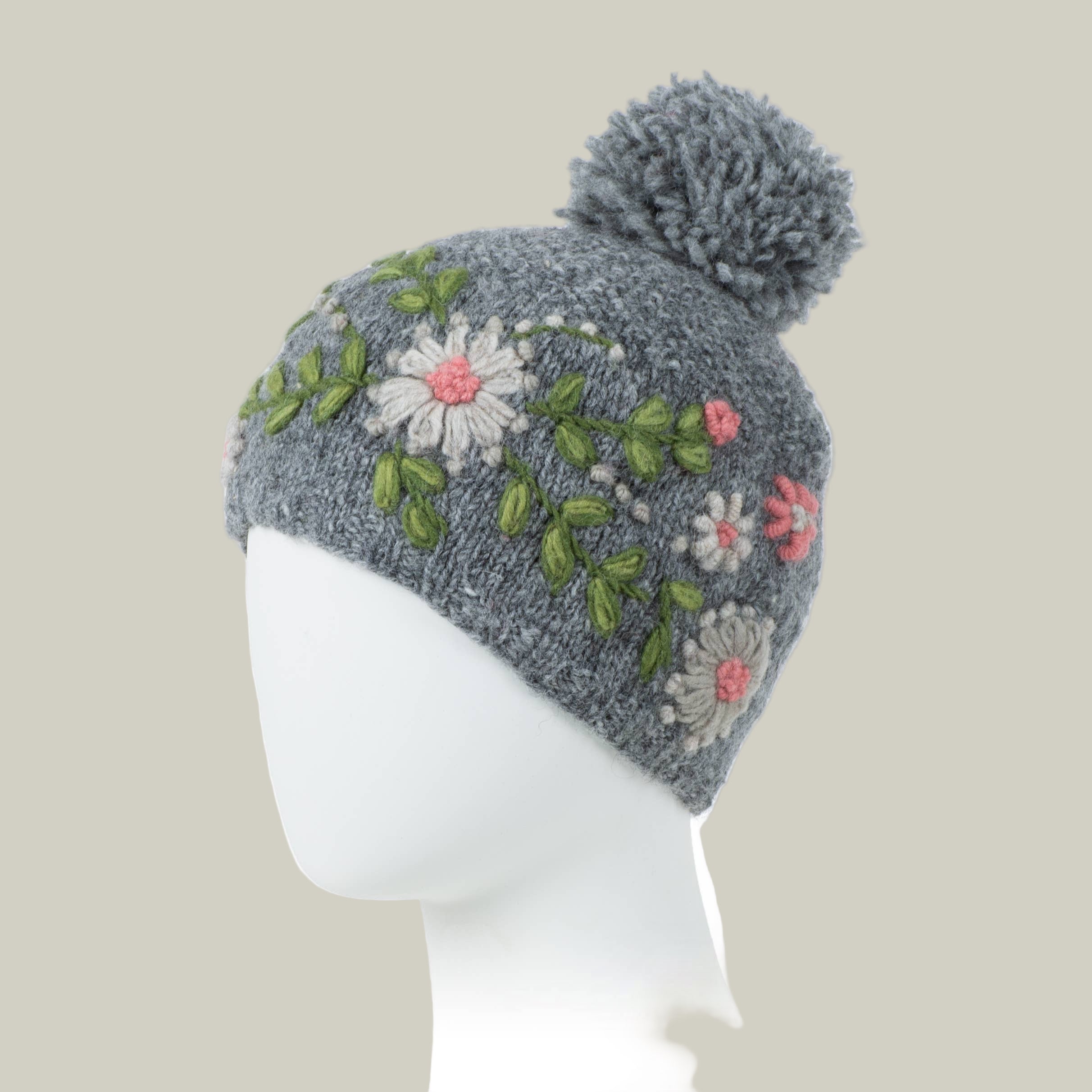Heather grey hand knit hat with floral embroidery and a pom-pom 