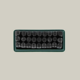 Set of metal stamps in a rectangular tray on a light green background