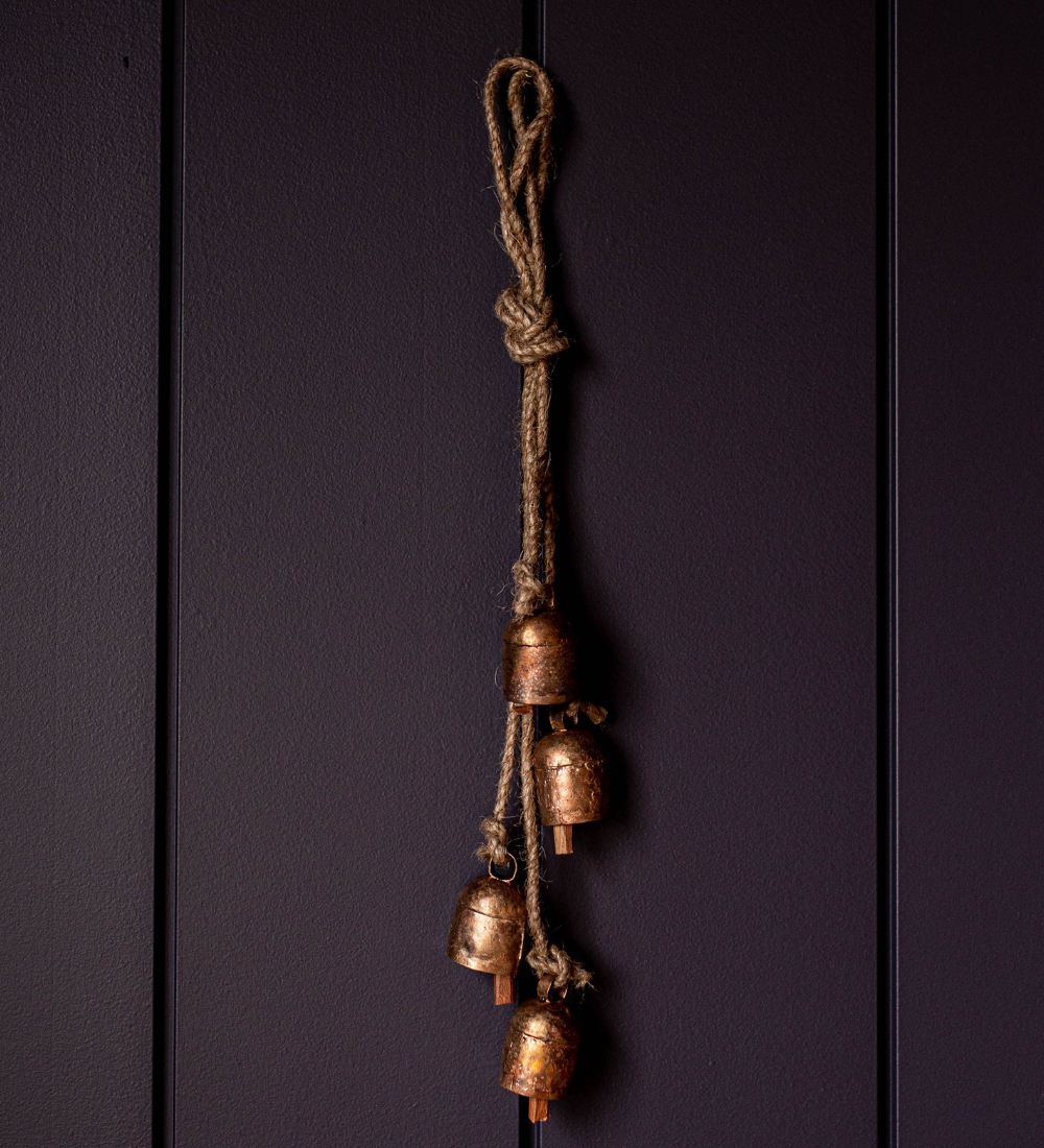 Brass bells on a rope against a dark purple background