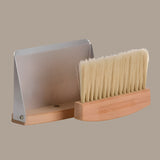 Brush with wooden handle and metal base on a beige background