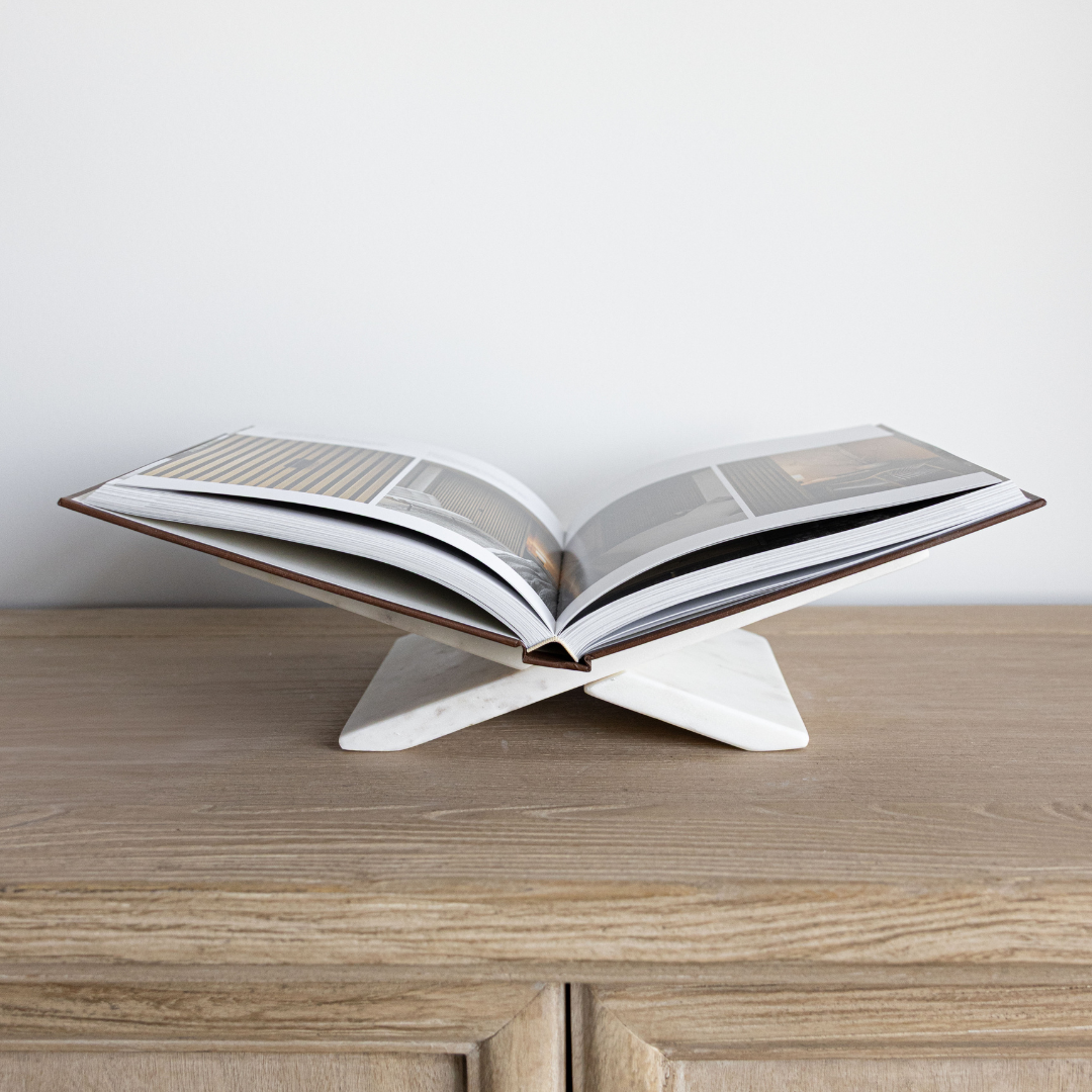 Open book on a marble book stand with a plain background