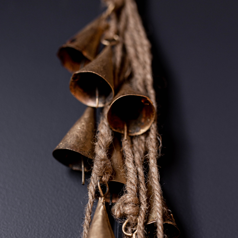 Vintage-style metal bells hanging on a dark background