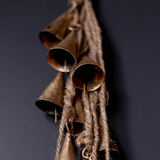 Vintage-style metal bells hanging on a dark background