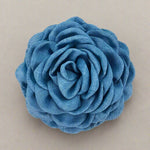 Blue fabric flower hair clip on a cream background